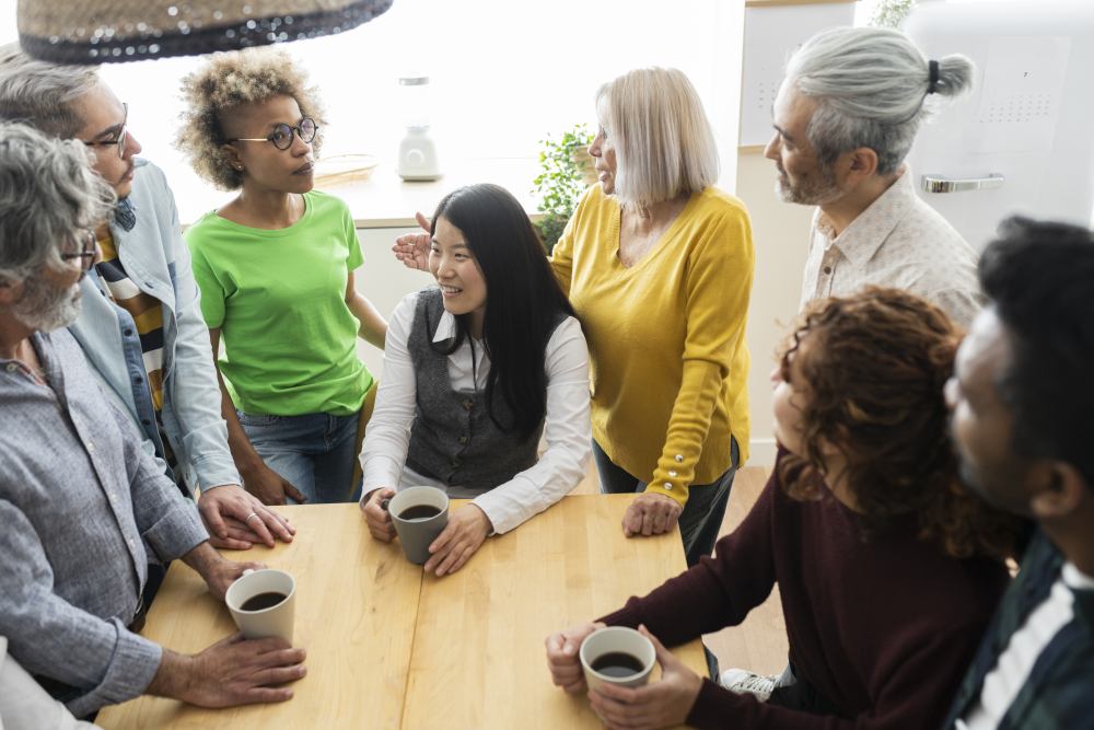 group gathering at wooden table with coffee cups